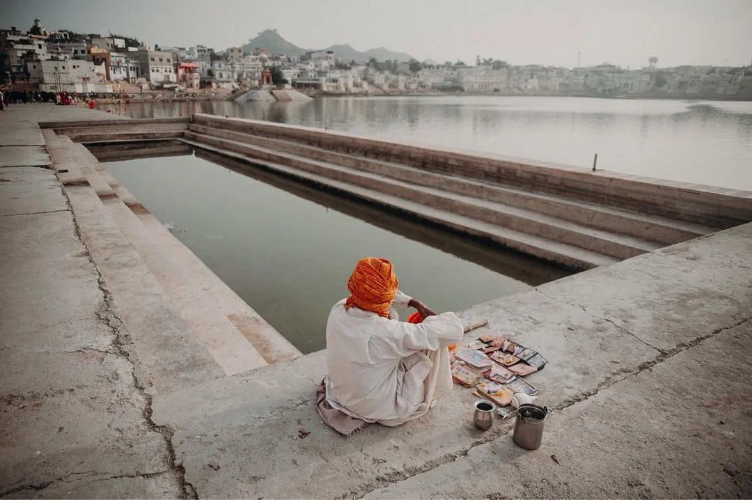 Scene of a man sitting in front of Pushkar lake in India