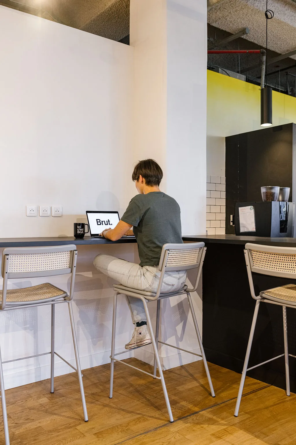 Collaborateur au travail dans les bureaux de Brut à Paris, lumière naturelle
