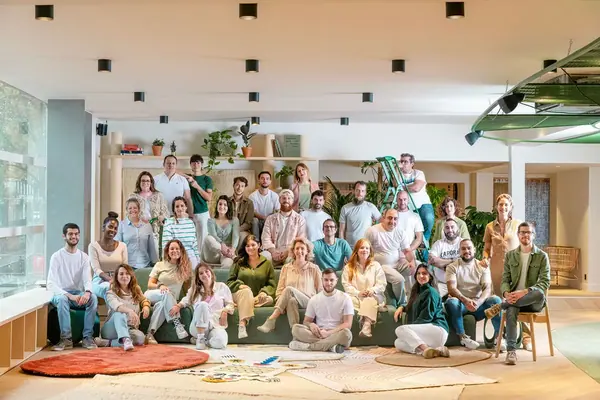 Photo d'équipe de Yemanja réunie sur des canapés dans un espace de bureaux lumineux, portrait corporate collectif