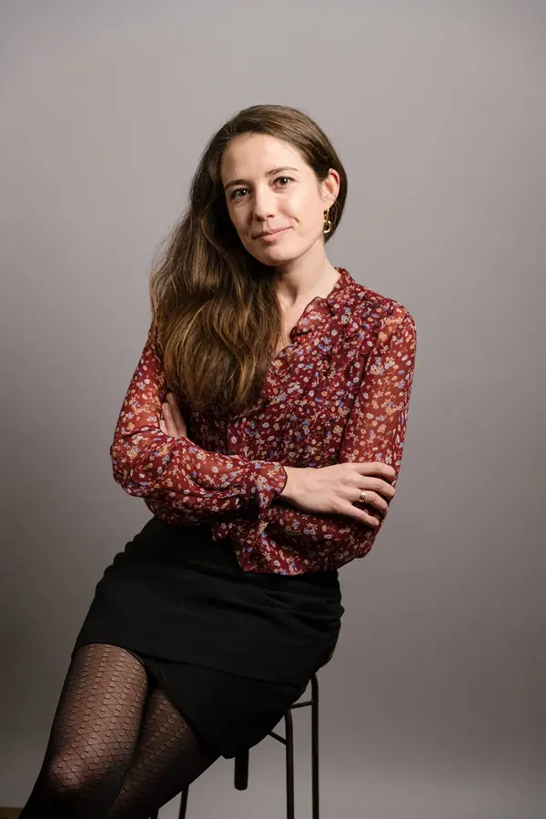 Portrait de collaboratrice en blouse imprimée sur fond gris, série homogène de portraits d'équipe pour une entreprise à Paris