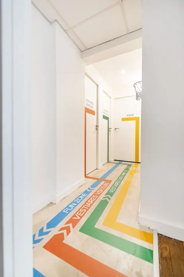 Couloir avec signalétique au sol en bandes colorées dans les bureaux Eulidia, aménagement Yemanja, architecture intérieure
