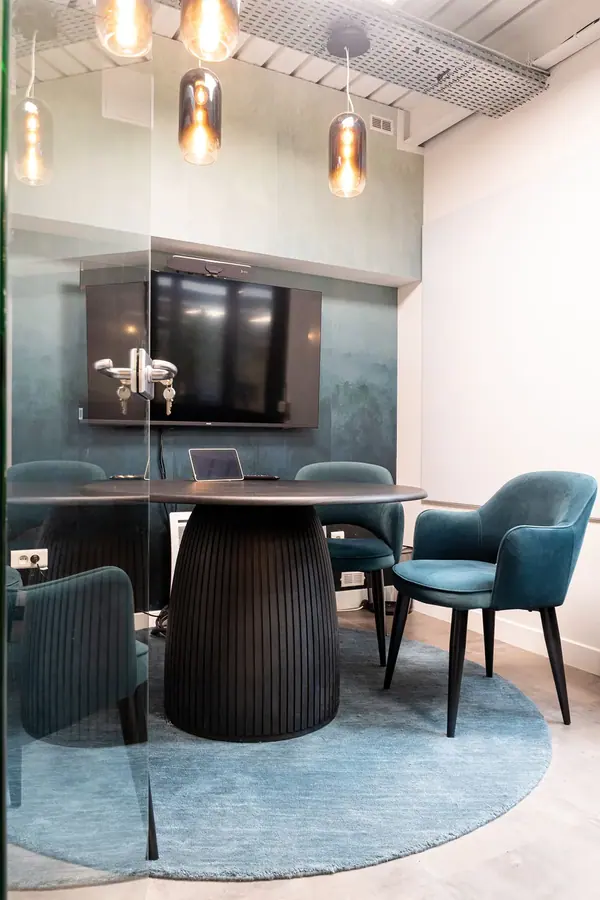 Salle de réunion aux fauteuils en velours bleu canard et table ronde, bureaux Allure par Yemanja, architecture intérieure