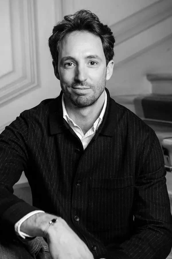 Portrait en noir et blanc d'un homme en veste rayée, assis dans un intérieur aux moulures, série pour Francéclat