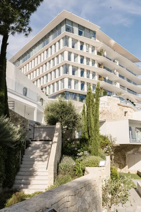 Photographie d'architecture de l'hôtel The Maybourne Riviera à Roquebrune-Cap-Martin, façade en terrasses et cyprès