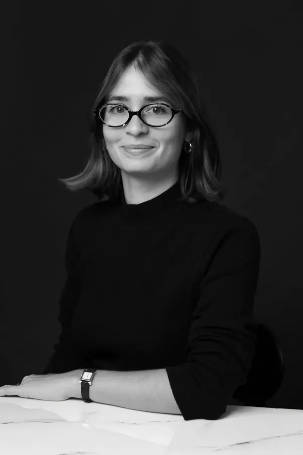 Portrait corporate noir et blanc d'une parfumeuse à lunettes en col roulé noir, studio à Paris