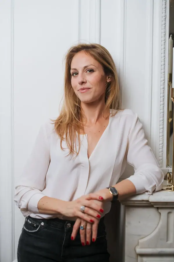 Portrait professionnel en lumière naturelle d'une femme en blouse claire, dans un intérieur parisien