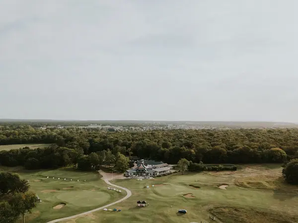 Vue aérienne d'un parcours de golf et de son club-house entouré de forêt, reportage photo de l'événement Les Echos