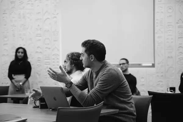 Échanges autour d'une table ronde Singular à Paris, participants en discussion, reportage photo noir et blanc