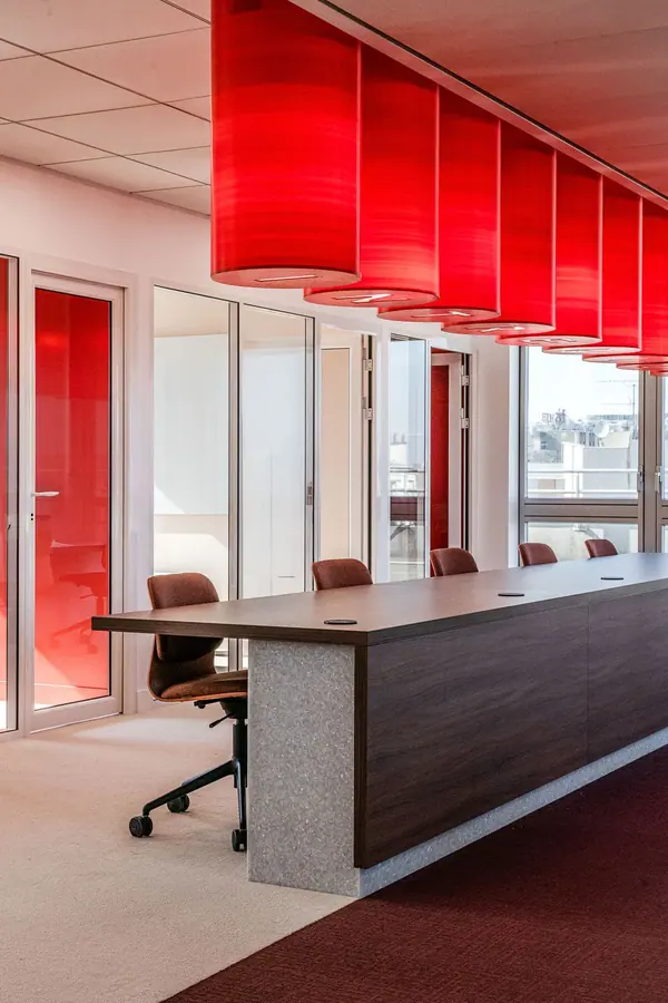 Bureaux Steerone à Paris par Yemanja : colonnes lumineuses rouges au-dessus d'un long bureau partagé, photo d'architecture