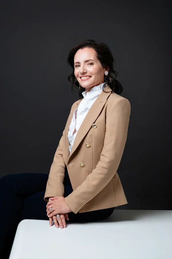 Portrait corporate de Virginie Flam, dirigeante d'Idemia, assise en veste beige