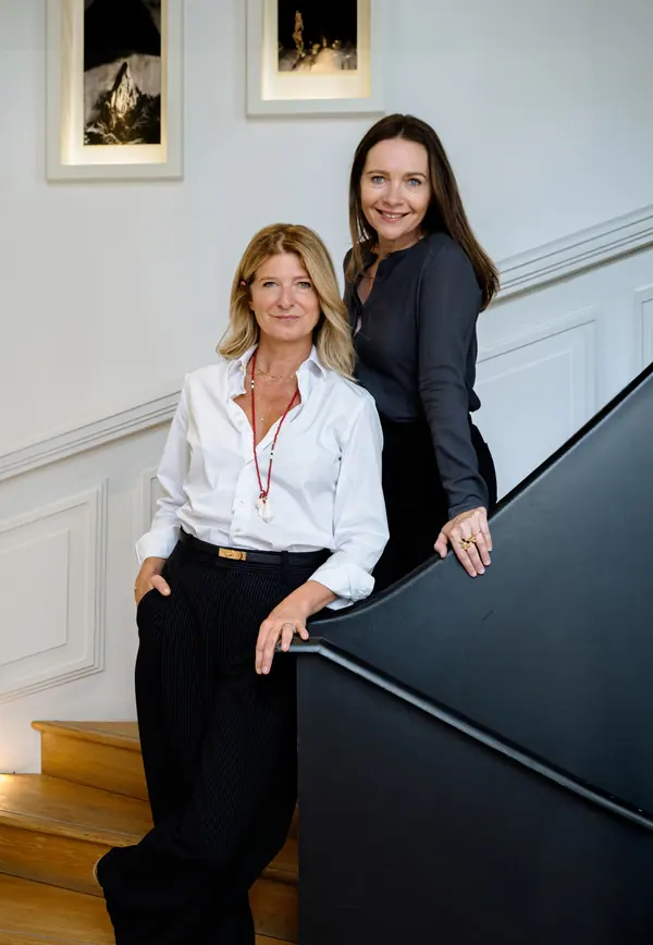 Deux dirigeantes de Semantiweb posant dans un escalier aux murs blancs, portrait corporate du comité exécutif