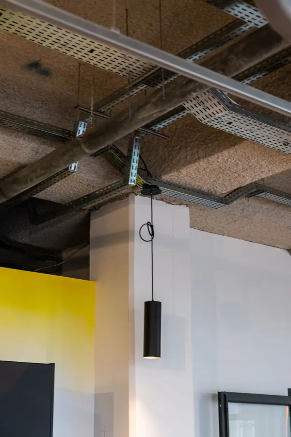 Photographie d'architecture intérieure des bureaux de Brut à Paris, plafond technique apparent et suspension noire