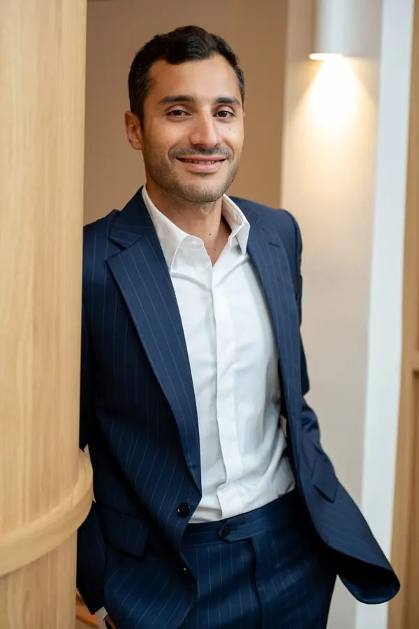 Portrait corporate d'un collaborateur en costume bleu dans les locaux de son entreprise à Paris
