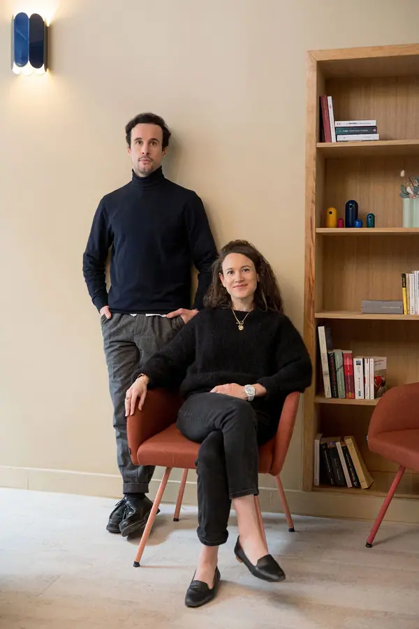 Portrait corporate de deux associés de Leosquare dans un intérieur clair, l'un debout, l'autre assise sur un fauteuil