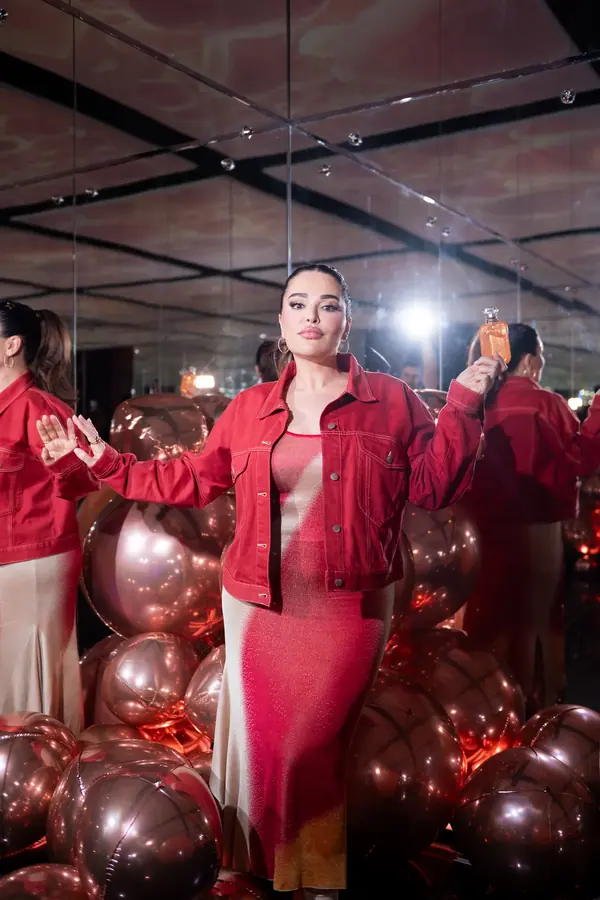 Invitée en tenue rouge au milieu de ballons roses lors d'un événement de lancement Kayali, reportage photo événementiel