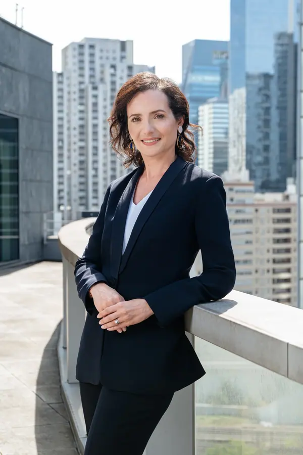 Portrait de Virginie Flam, dirigeante d'Idemia, accoudée sur une terrasse face aux tours de La Défense