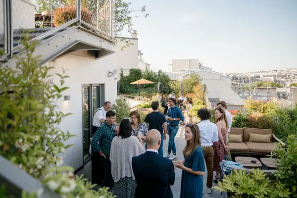Reportage photo d'une soirée sur un rooftop parisien pour Singular, invités sur une terrasse végétalisée au soleil